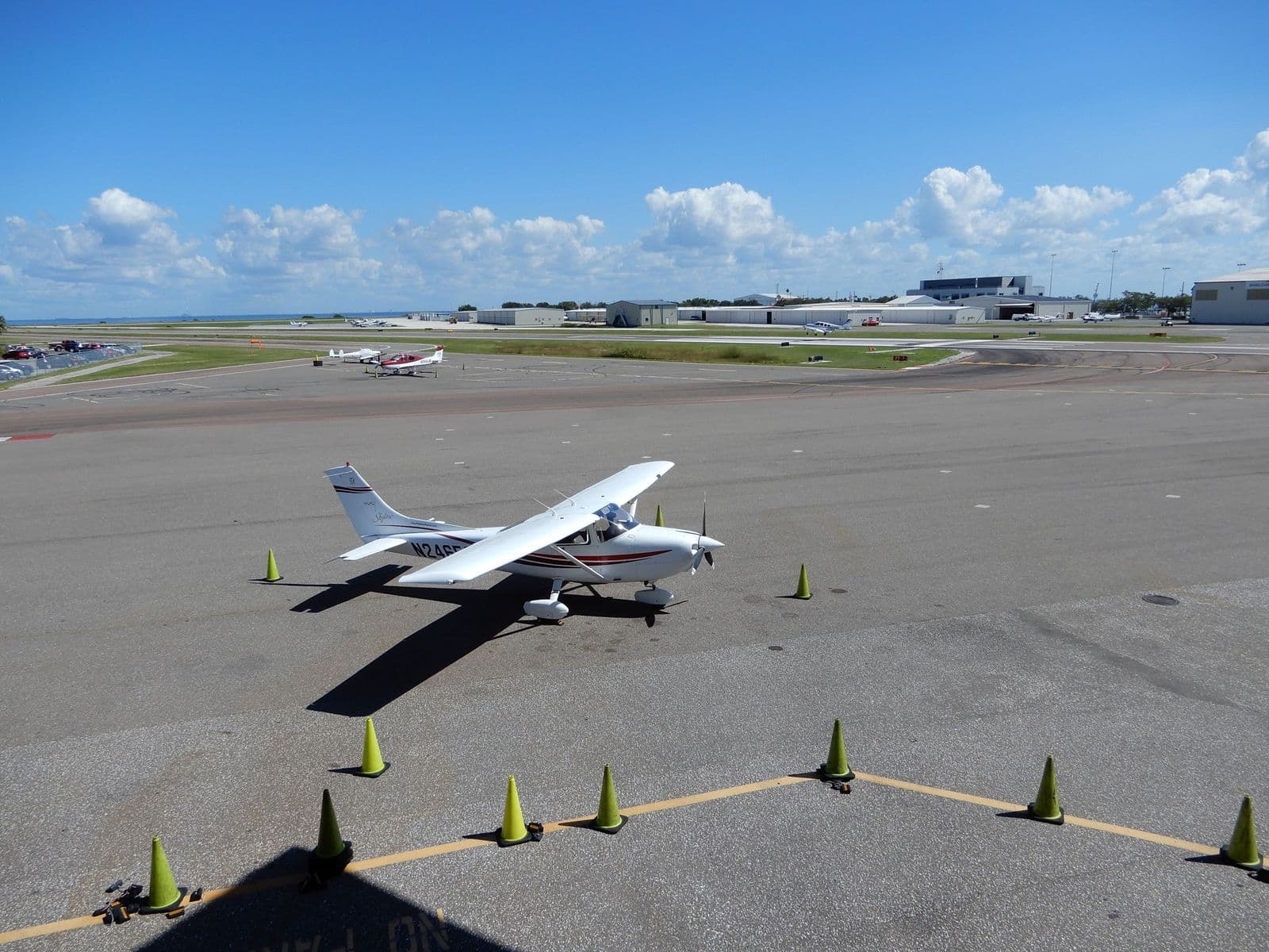 Naše Cessna 182 na stojánce letiště Albert Whitted, výhled z letištní restaurace