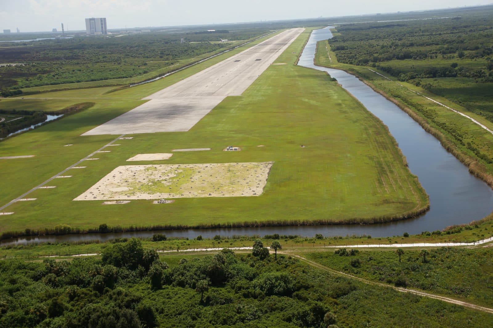 Přistávací dráha raketoplánů na Cape Canaveral z výšky, v pozadí montážní hala
